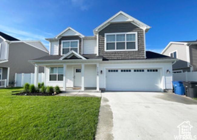 View of front facade with driveway, a garage, and covered porch | Image 19