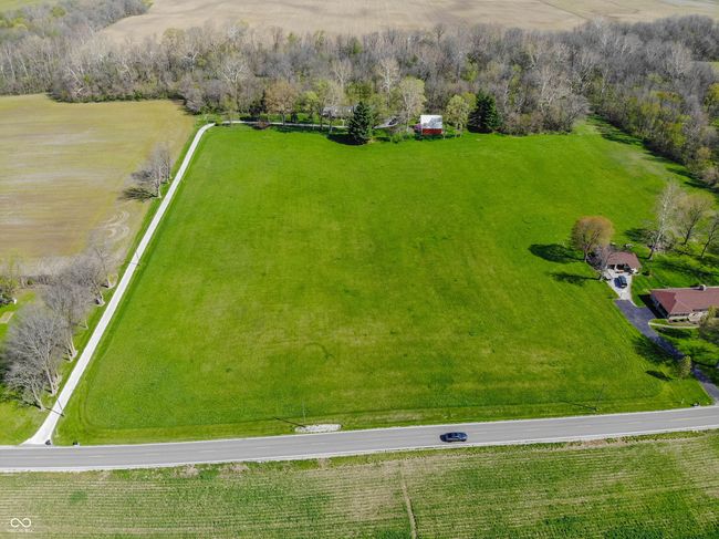 Drone / aerial view showing the 8 acres of pasture and the wooded backyard. | Image 8