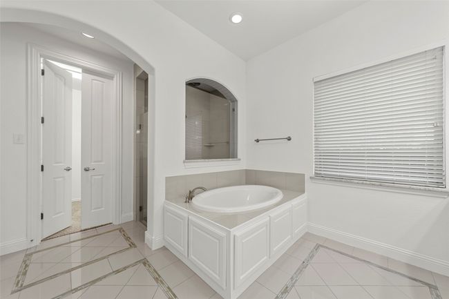 Bathroom with baseboards, tile patterned flooring, a shower stall, and a garden tub | Image 20