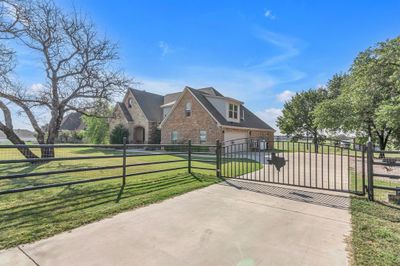 View of gate with a lawn and a garage | Image 3