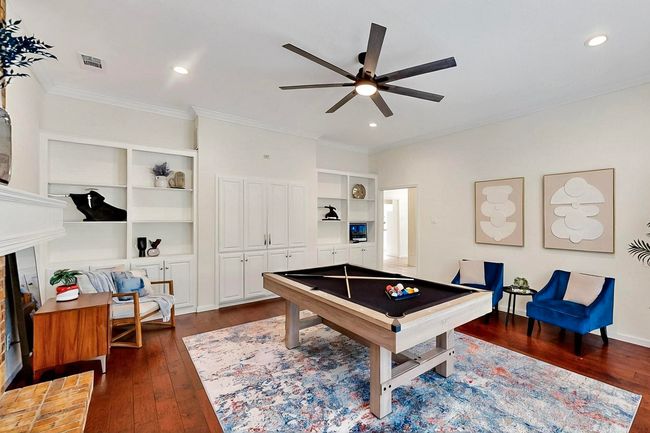 Game room featuring ceiling fan, dark wood-type flooring, built in shelves, crown molding, and billiards | Image 6