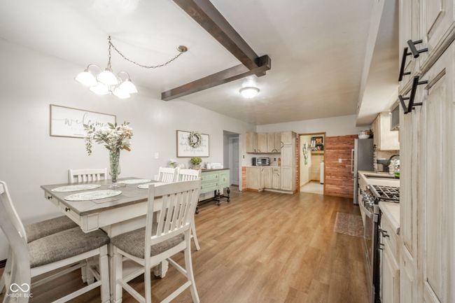 dining room featuring an inviting chandelier, light wood finished floors, and beam ceiling | Image 25