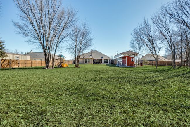 View of yard with a playground and a storage unit | Image 26