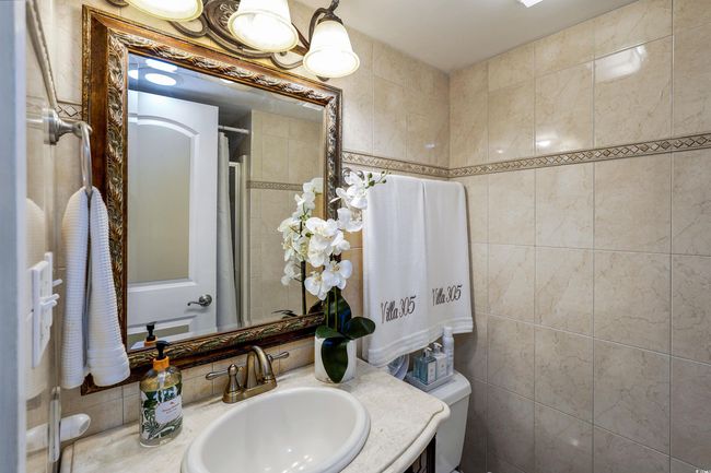 Bathroom featuring toilet, vanity, tile walls, and a shower | Image 22