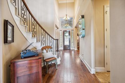 The curved stairs accent the two story entry with wood flooring | Image 2