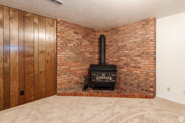 Detailed view of carpet, a wood stove, and a textured ceiling | Image 20