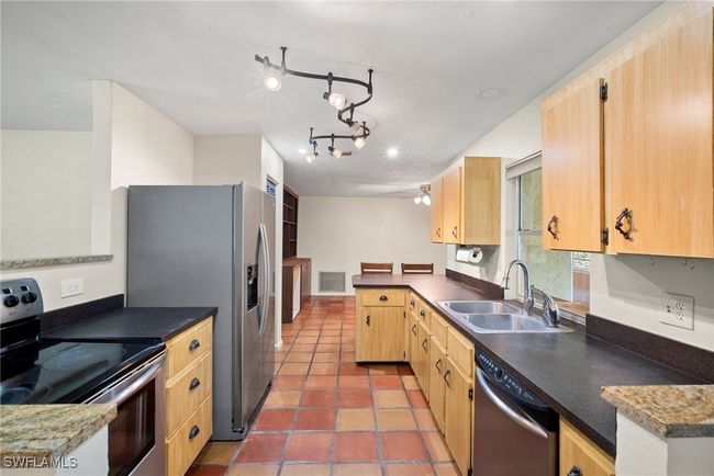 Kitchen with stainless steel appliances, rail lighting, sink, tile patterned floors, and kitchen peninsula | Image 9