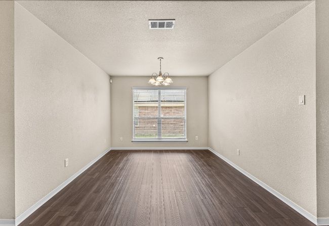 Unfurnished room featuring a chandelier, a textured wall, dark wood-style flooring, and a textured ceiling | Image 18