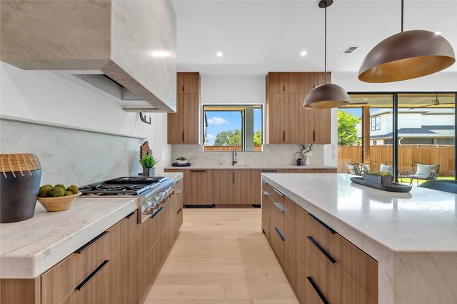 Kitchen with stainless steel gas stovetop, modern cabinets, light wood-type flooring, backsplash, and recessed lighting | Image 8