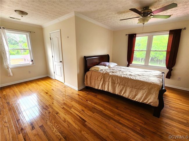 Bedroom featuring a textured ceiling, hardwood / wood-style floors, ceiling fan, and crown molding | Image 20