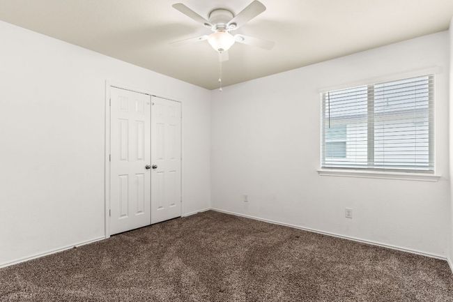 Unfurnished bedroom with dark colored carpet, a closet, and ceiling fan | Image 21