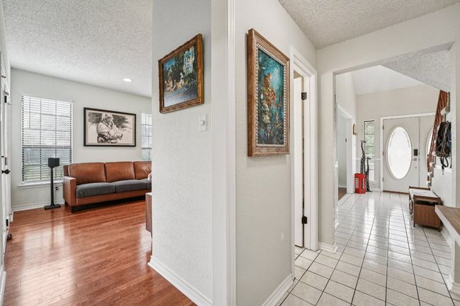 Hallway featuring a textured ceiling, light tile patterned flooring, and a textured wall | Image 13