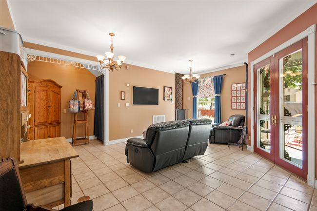 Living area featuring light tile patterned floors, ornamental molding, and an inviting chandelier | Image 15