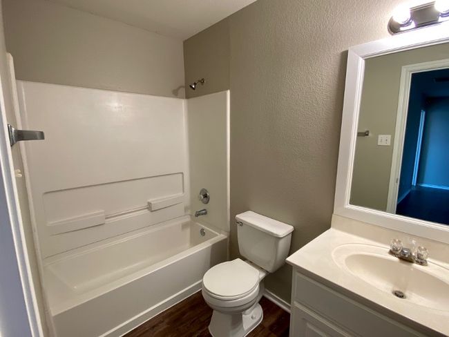 Full bathroom with vanity, wood finished floors, bathtub / shower combination, and a textured wall | Image 27
