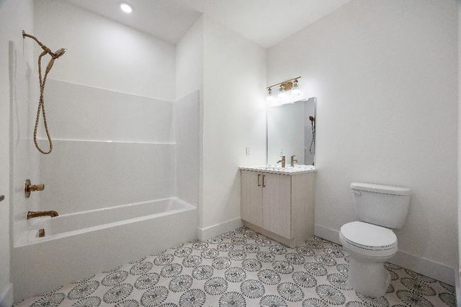 Full bathroom featuring toilet, baseboards, vanity, and shower / bath combination | Image 16
