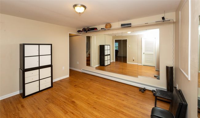 Workout area featuring wood finished floors and a baseboard radiator | Image 43