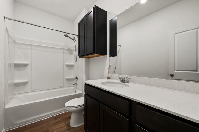 Full bathroom featuring wood finished floors, vanity, and washtub / shower combination | Image 25