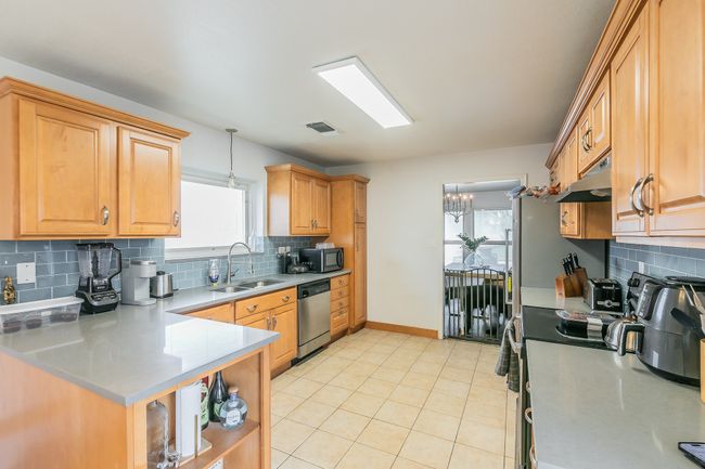 Unit 4900 Another view of Kitchen with stainless steel dishwasher, decorative light fixtures, sink, and backsplash | Image 10