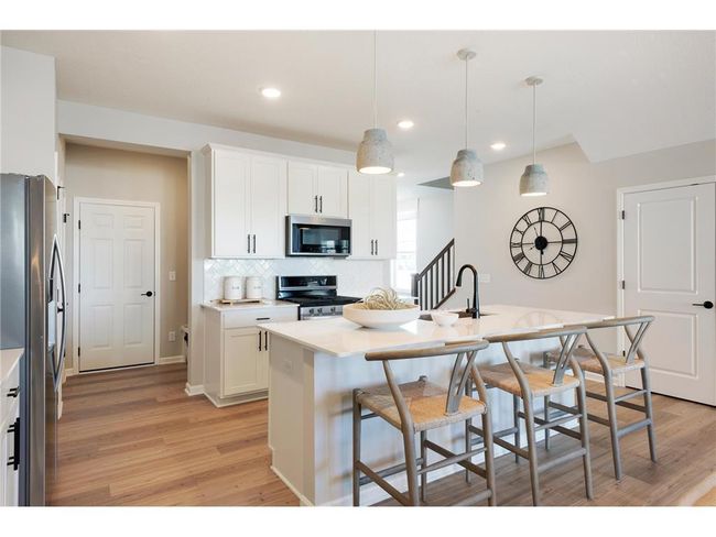 The Ashton's kitchen features a huge island surrounded by even more quartz counters. Durable and beautiful is a great combo! Photo of model home. | Image 25
