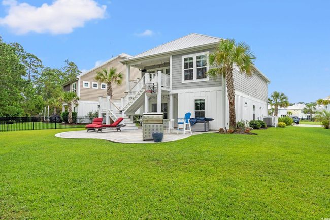Rear view of property featuring a patio, stairway, a balcony, board and batten siding, and ceiling fan | Image 23