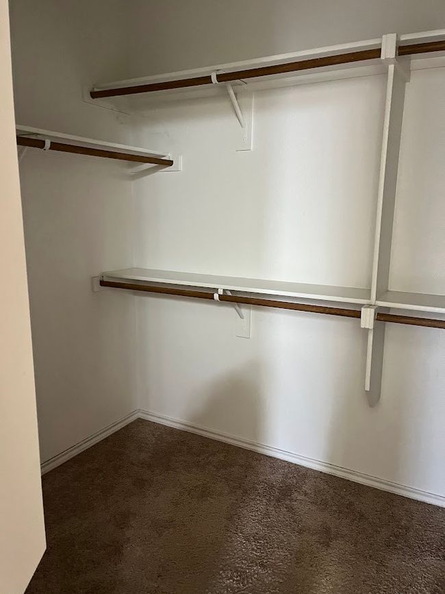 Spacious closet with dark carpet | Image 28