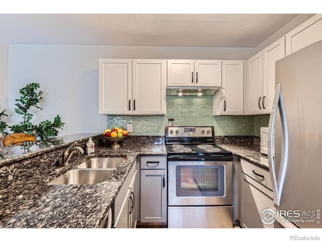 Stylish Tuxedo Kitchen with Vibrant Glass Backsplash, Granite Counters and New Stainless Appliances | Image 8
