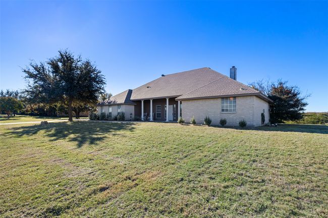 View of front of house featuring brick siding, a chimney, and a front lawn | Image 5