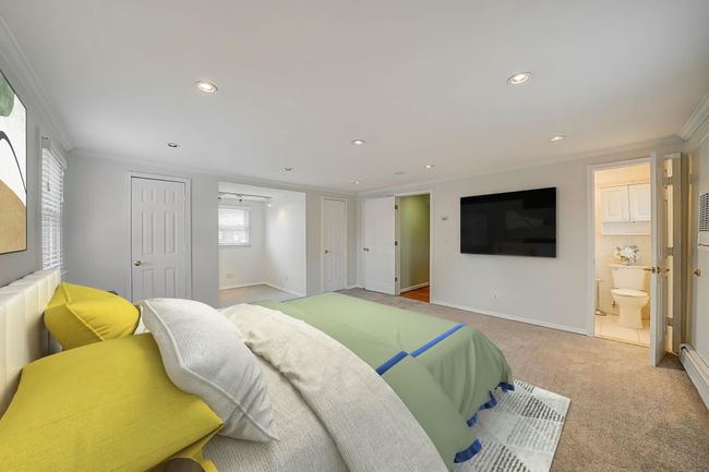 Bedroom featuring ensuite bathroom, crown molding, and light carpet | Image 21