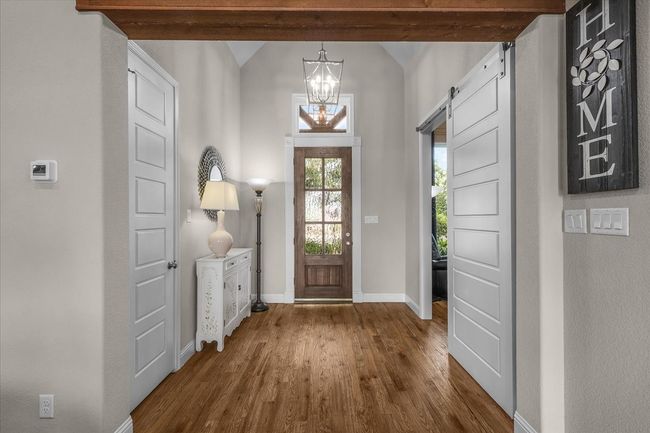 Entrance foyer featuring a barn door, a chandelier, and vaulted ceiling | Image 8