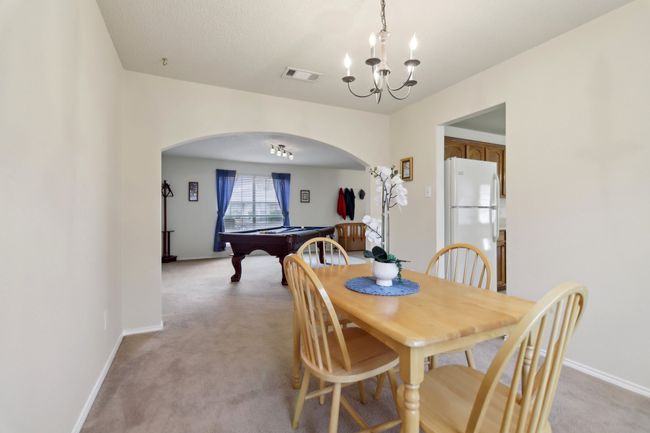 Dining area featuring visible vents, light carpet, arched walkways, pool table, and a notable chandelier | Image 12