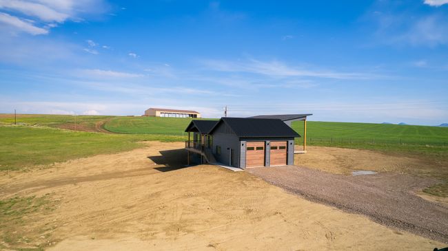 View of outdoor structure with driveway, a rural view, and an attached garage | Image 13