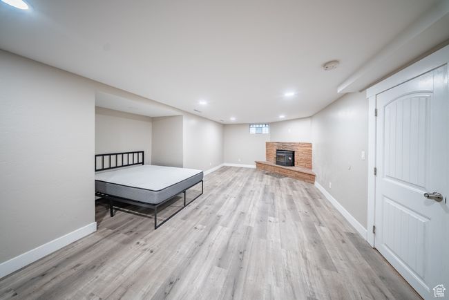 Bedroom with light wood-type flooring, a stone fireplace, and recessed lighting | Image 19