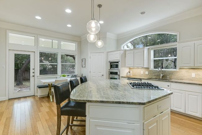 Kitchen featuring stainless steel appliances, large center island, and granite countertops. | Image 11