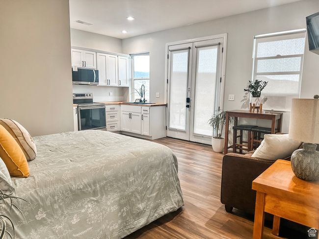 Bedroom featuring access to exterior, french doors, a sink, wood finished floors, and recessed lighting | Image 28