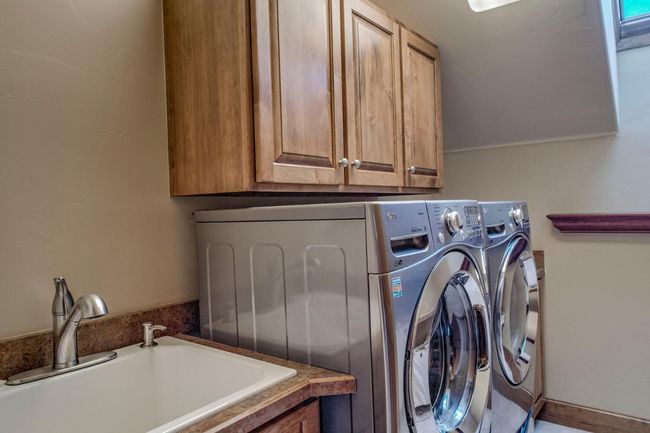 Laundry with utility sink on top level of the home. | Image 31