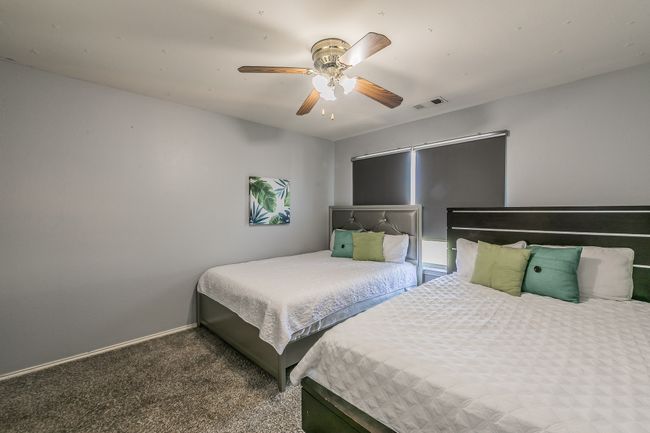 Bedroom featuring a ceiling fan and carpet flooring | Image 24