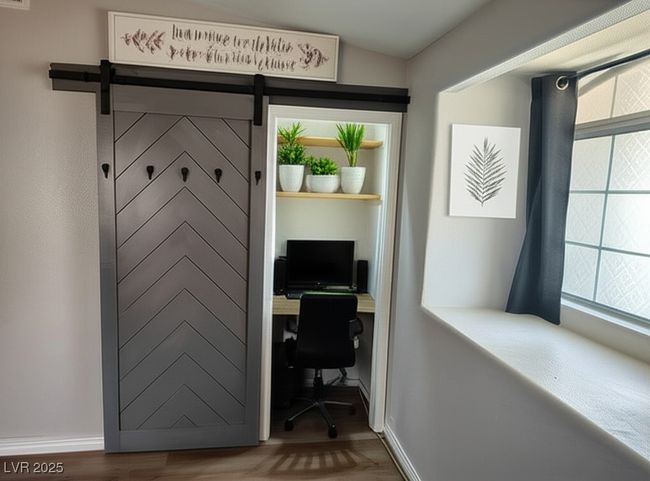 Office with a barn door, wood finished floors, and built in desk | Image 10