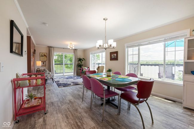 dining space featuring ornamental molding, a chandelier, wood finished floors, and baseboards | Image 13