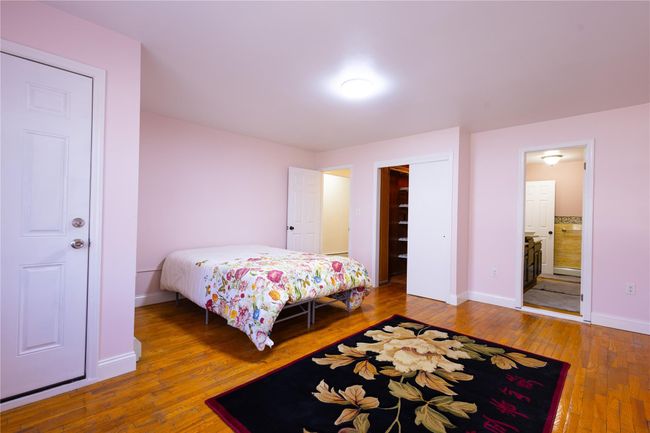Bedroom featuring ensuite bathroom, baseboards, and wood-type flooring | Image 13