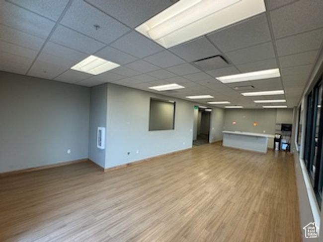 Unfurnished room with light wood-type flooring, a drop ceiling, and fire sprinkler in ceiling | Image 36