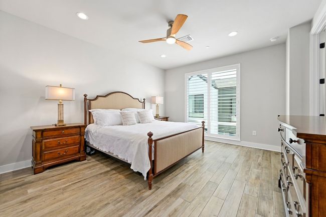Primary bedroom features oversized windows w/ plantation shutters, walk-in closet, and ensuite bathroom. | Image 21
