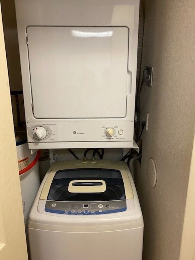 Laundry area featuring stacked washer and clothes dryer and laundry area | Image 12