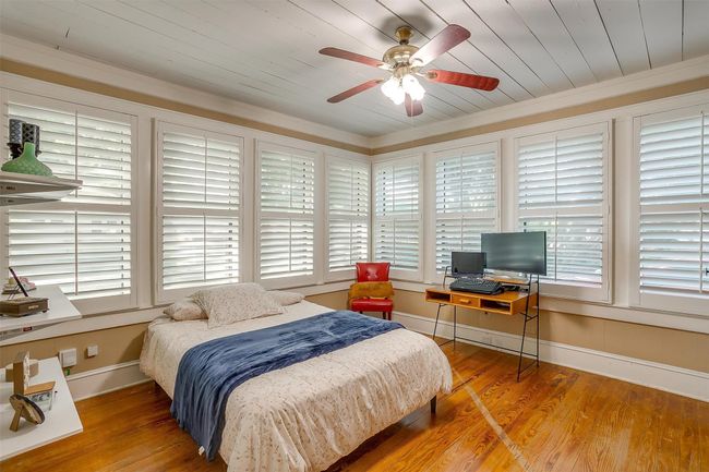 Bedroom with multiple windows, wood finished floors, crown molding, wooden ceiling, and ceiling fan | Image 31