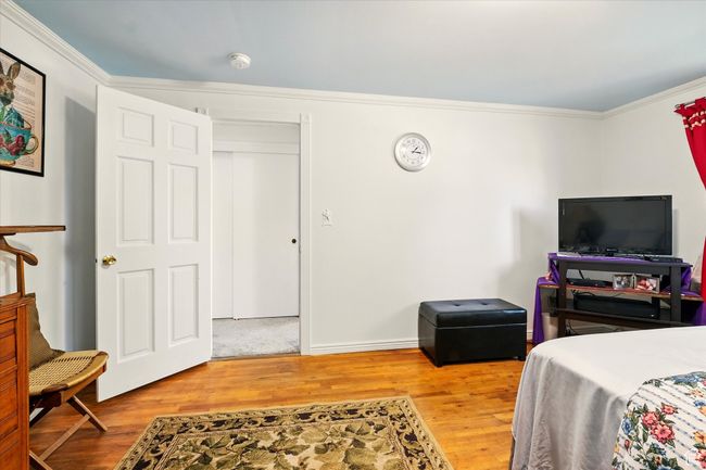 Bedroom featuring ornamental molding, wood finished floors, and baseboards | Image 19