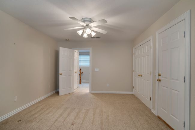 Unfurnished bedroom featuring light colored carpet, baseboards, and ceiling fan | Image 28