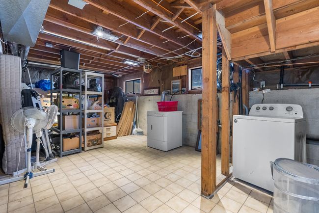 Unfinished basement featuring fridge and washer / dryer | Image 21