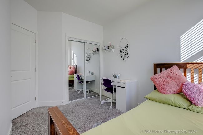 Carpeted bedroom with a closet and an office area | Image 14