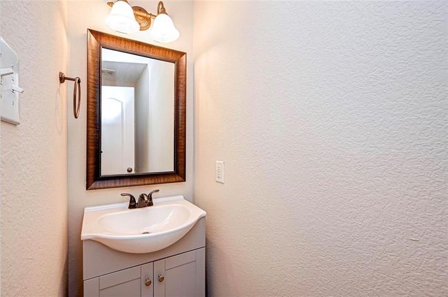 The half bath behind the kitchen offers convenience for guests. | Image 21