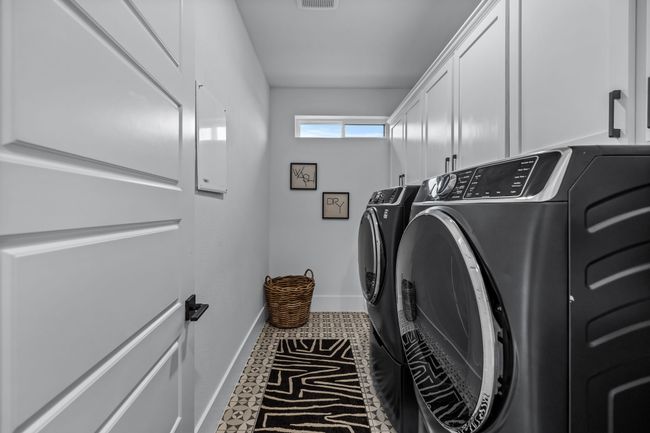 Washroom featuring tile patterned flooring, washing machine and dryer, and cabinets | Image 33