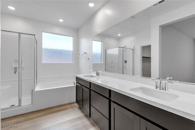 Bathroom with a shower stall, a bath, double vanity, wood finished floors, and recessed lighting | Image 26